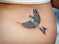 Татуировка ласточка внизу спины
