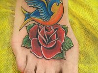 тату на ноге птичка с розой олдскул