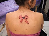 небольшая тату бант на спине
