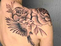 Тату птица с цветами на лопатке