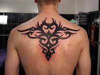 Мужская тату узор трайбл на спине