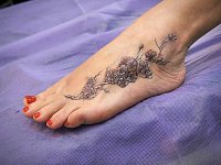 тату ветка сакуры на ноге у девушки