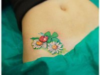 тату божья коровка в цветах на животе