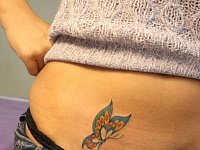 Женская тату бабочка на животе