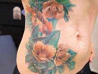 тату птицы в цветах на животе реализм