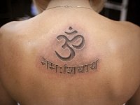 Татуировка "Ом" и надпись