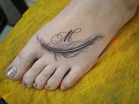 тату перо на ноге