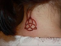 Тату трикветр на шее
