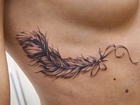 тату перо под грудью