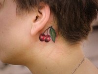 Тату вишни за ухом