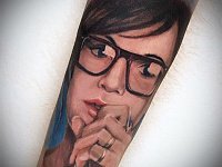 тату портрет девушки в очках на руке