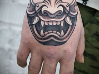 Тату японская маска на кулаке
