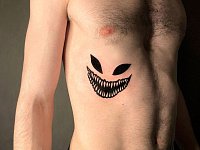 Тату улыбка чеширского кота на ребрах