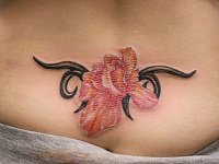 Женская тату цветок внизу спины